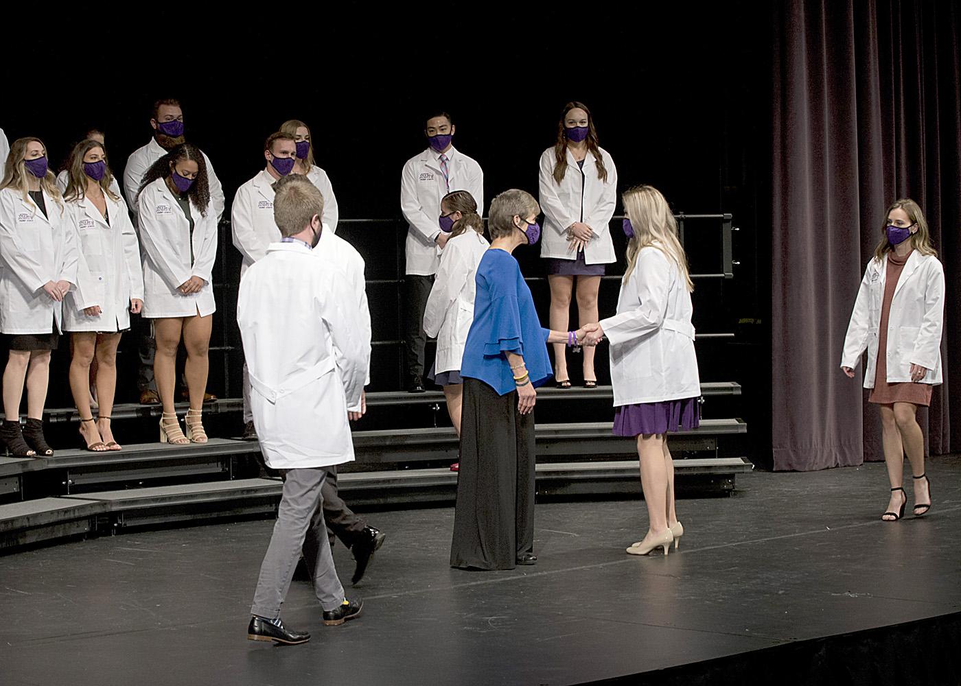 学生们在联合山的PT白大褂仪式上走过舞台