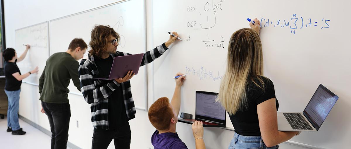 学生在白板上写方程式